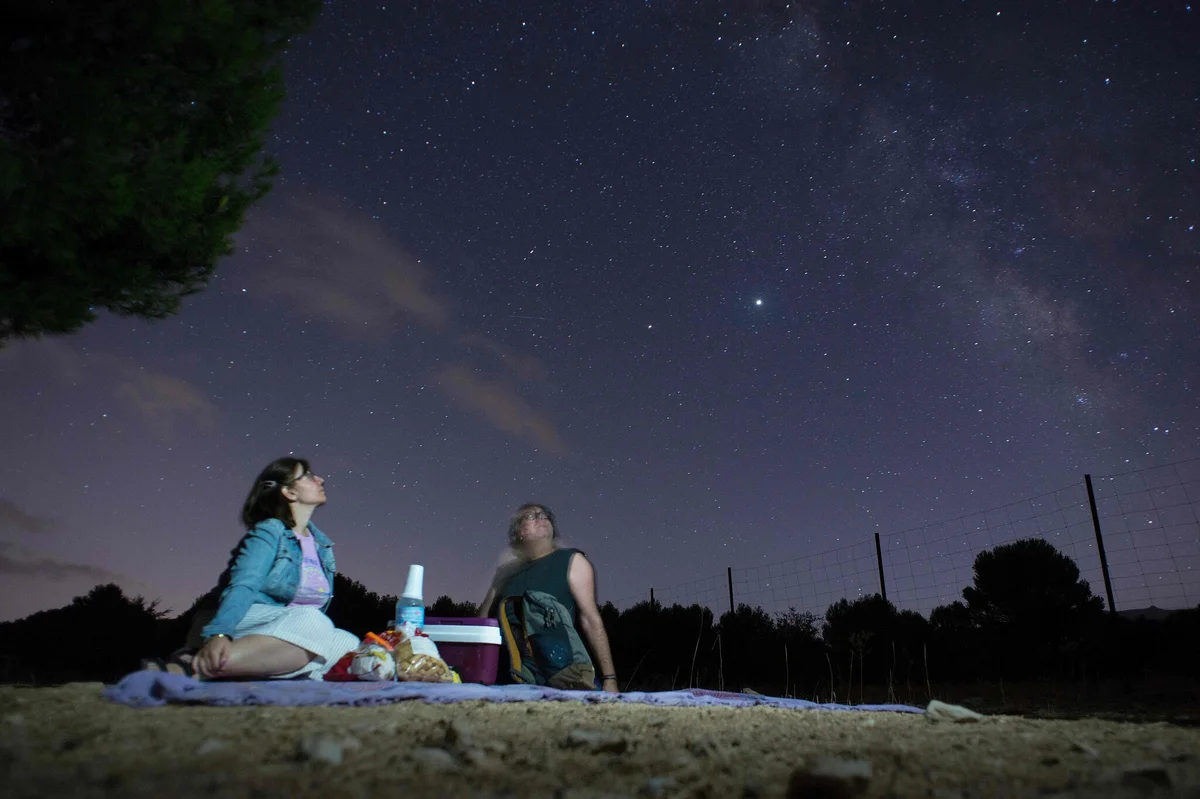 couple watching meteor shower blanket germany night