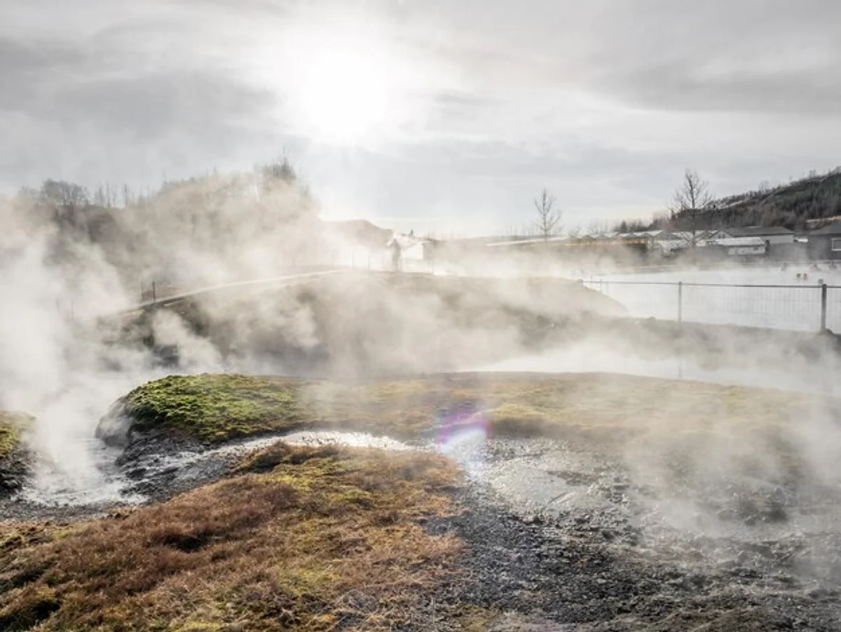 icelandic geothermal pool with mountains steam