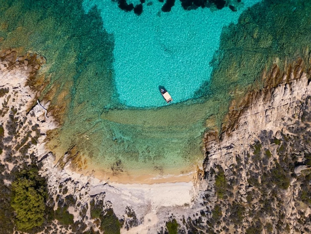 secluded bay greece turquoise water rocks aerial