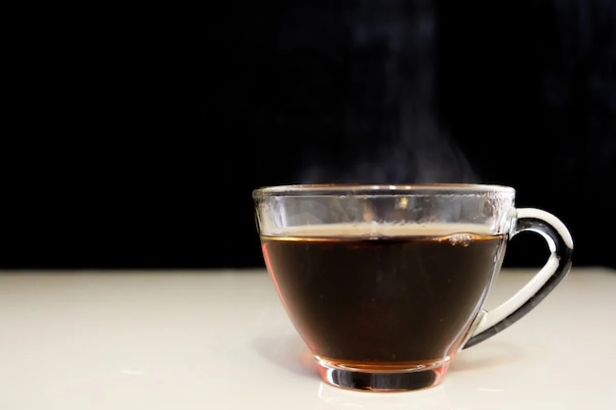 aromatic black coffee pouring in glass