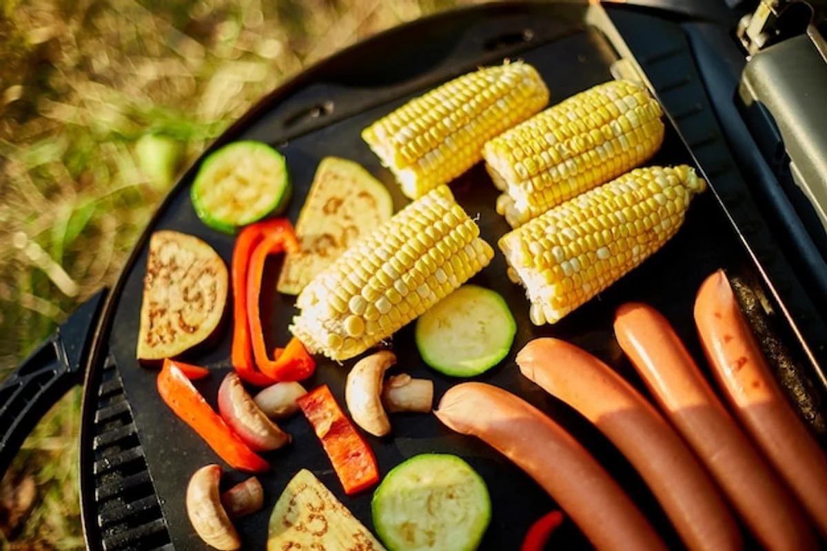 Close up of grilled vegan sausages with vegetables at a summer barbecue