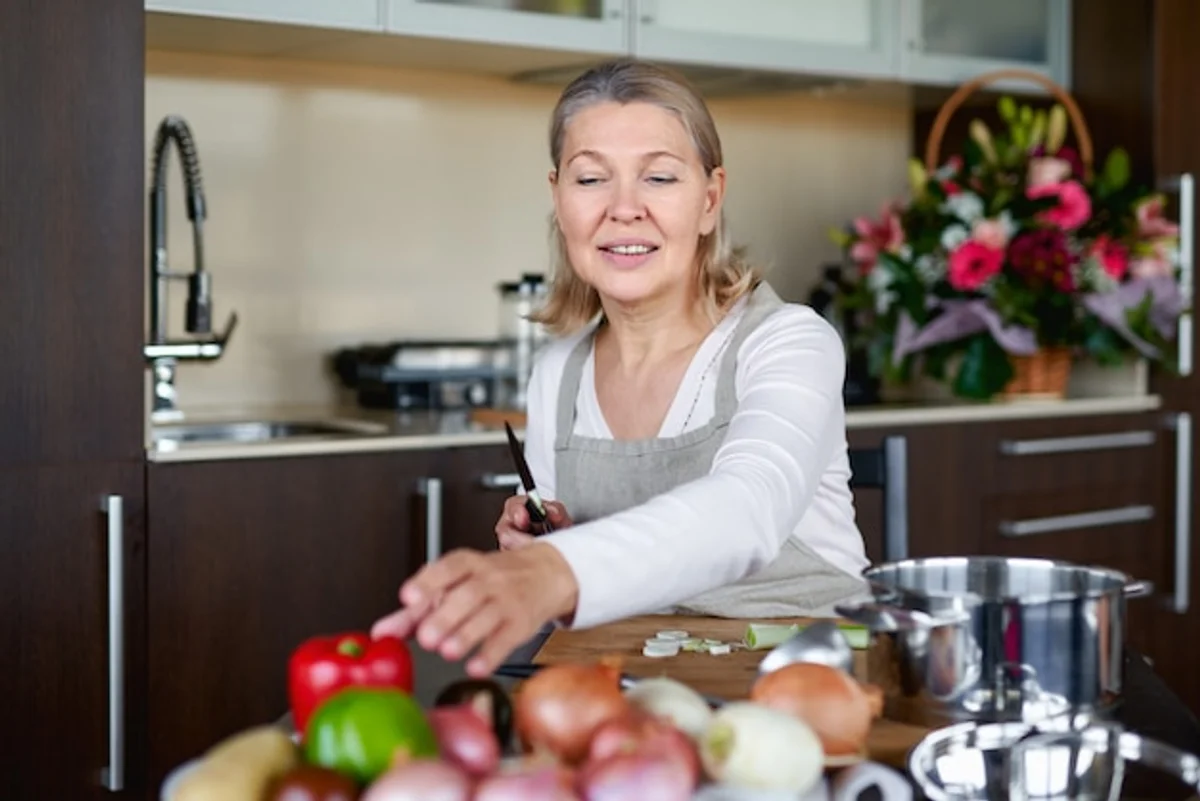 elderly person preparing superfood vegetable soup at home kitchen