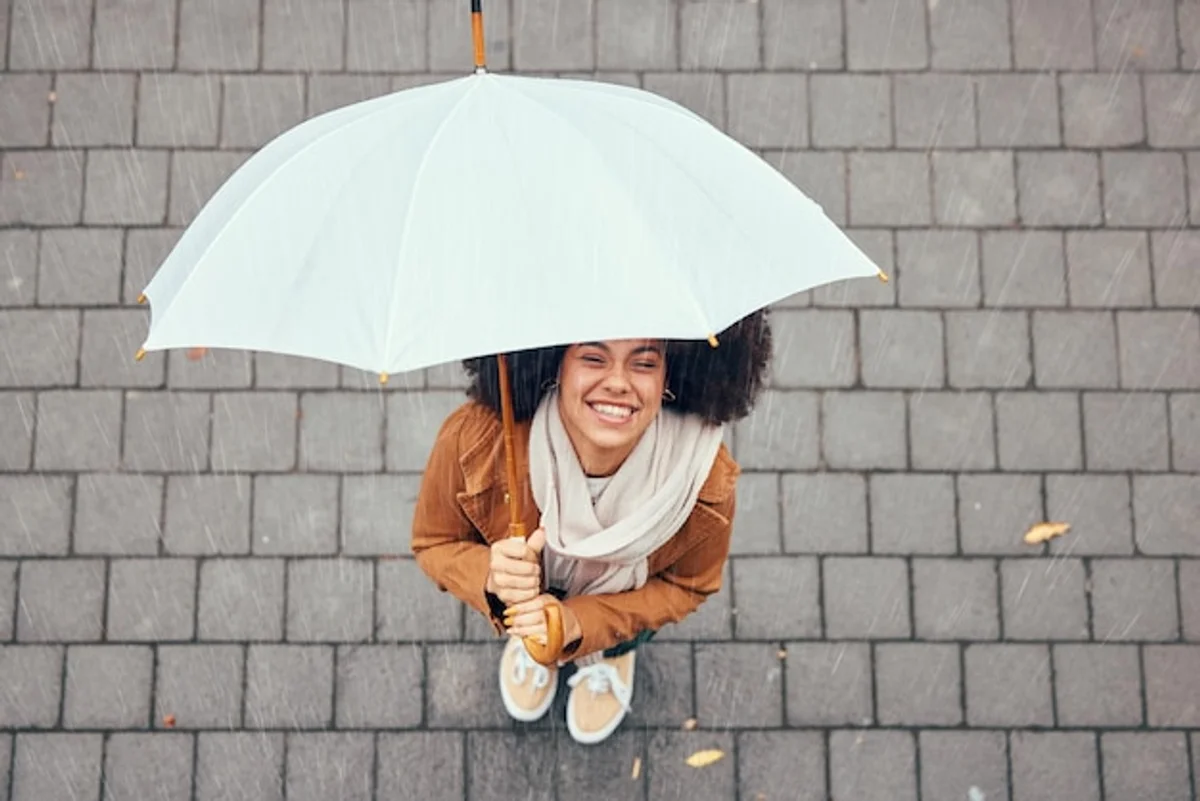 woman enjoying rain in city street happiness
