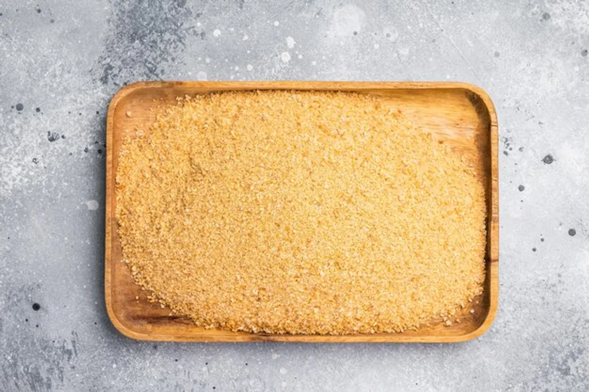 homemade storage jar with bread crumbs and bakery breads on wooden table