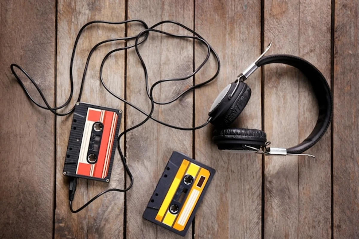 vintage walkman cassette on wooden table with headphones retro music closeup