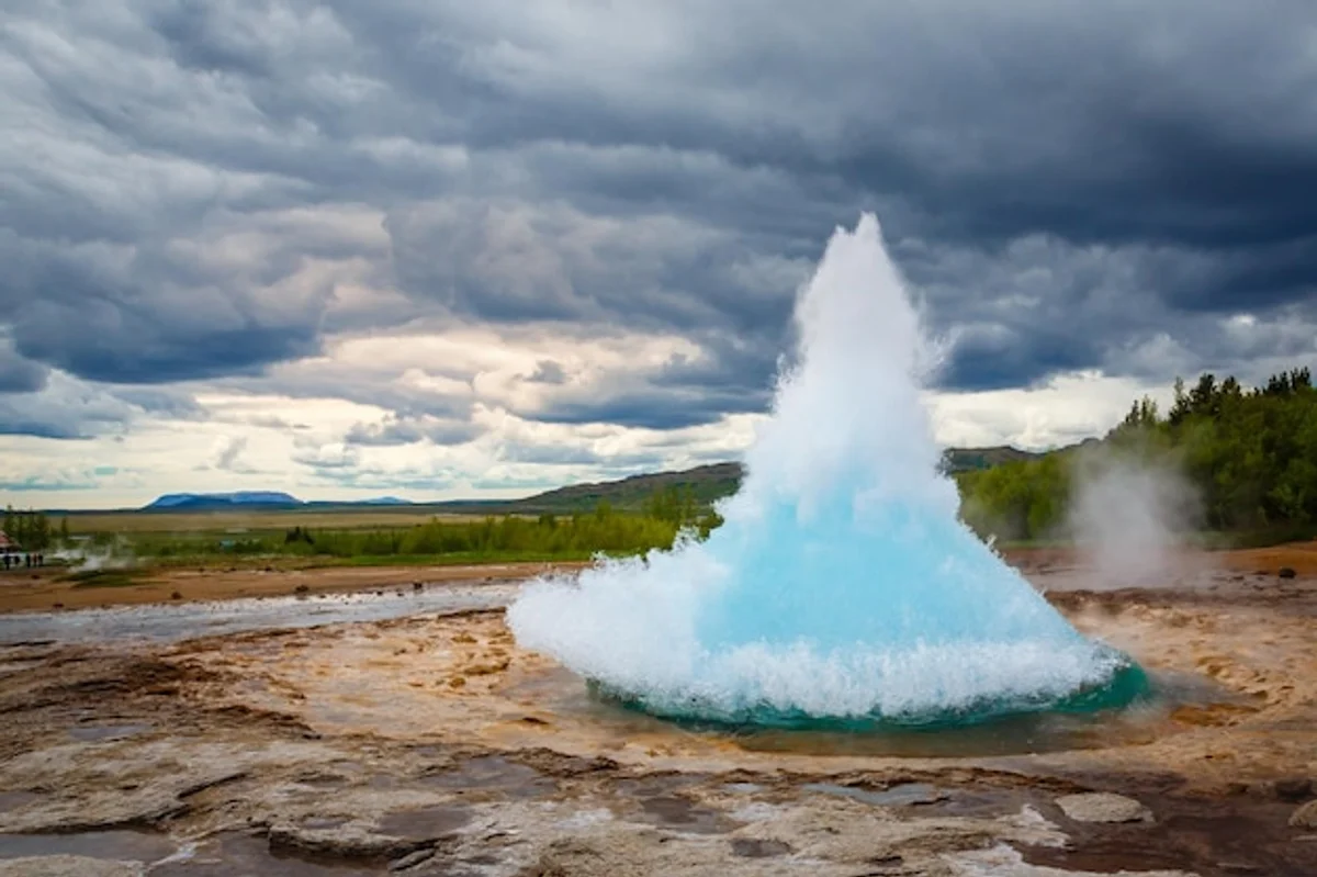 Strokkur geyser erupting in Iceland landscape