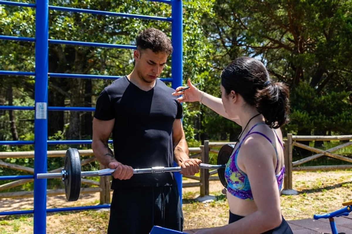 personal trainer correcting lifting posture gym