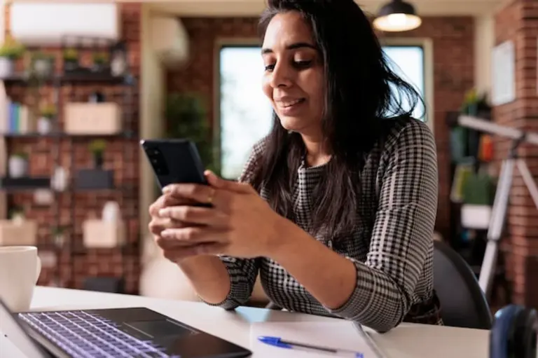 person using smartphone at home with wifi and electronic devices visible