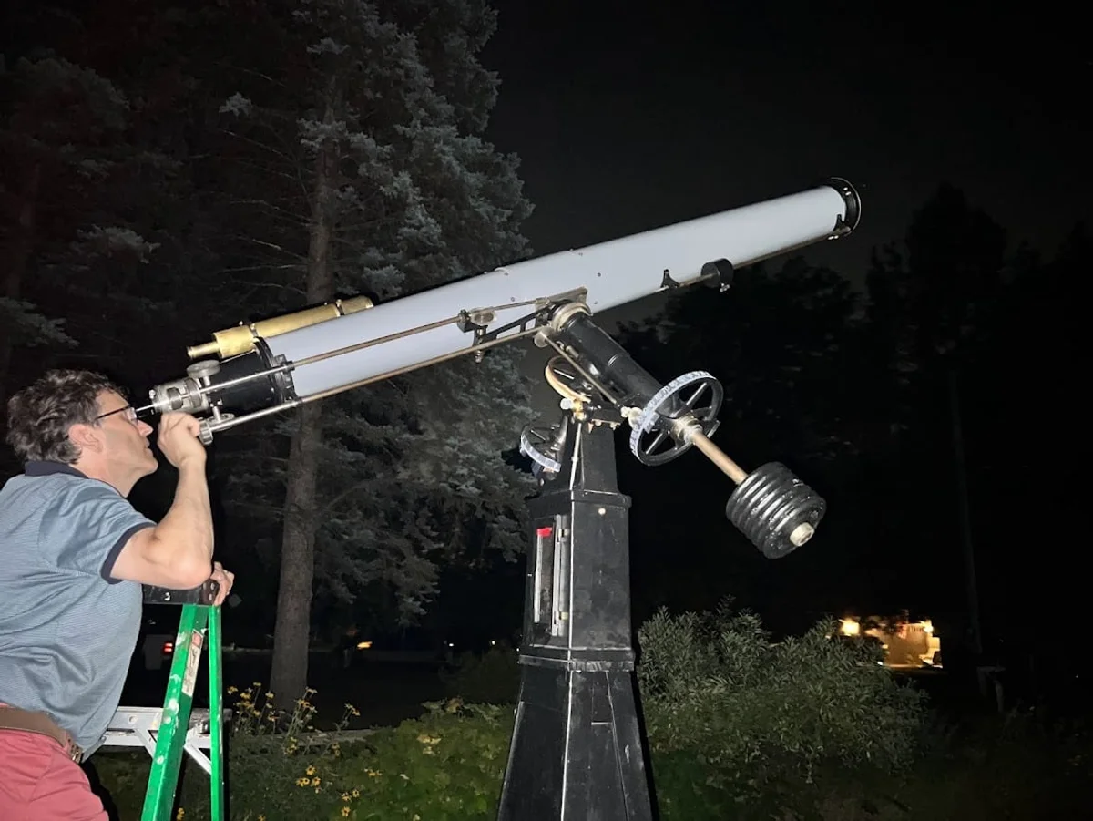 amateur astronomer with telescope under night sky germany